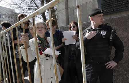 An Interior Ministry officer maintains order near people, who stand in a queue to get to an office of the presidential administration during an opposition protest, calling for Russian President Vladimir Putin not to run for another presidential term next year, in Moscow, Russia, April 29, 2017. REUTERS/Tatyana Makeyeva