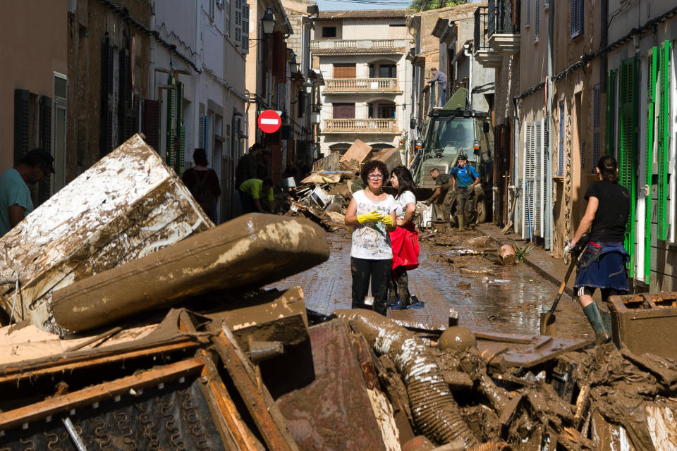 Residents remove destroyed furniture from their houses affected by flooding in Sant Llorenc, Mallorca, Spain, Thursday, Oct. 11, 2018. Spanish rescuers have found the bodies of a German couple that went missing after a destructive flash flooding that killed at least 10 more earlier this week in Mallorca and are still looking for a missing child. (AP Photo/Francisco Ubilla)