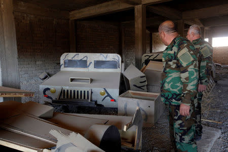 Iraqi Christian soldiers look at a fake military vehicle made of wood used by the Islamic State militants, in Qaraqosh, near Mosul, during an operation to attack Islamic State militants in Mosul, Iraq, November 2, 2016. REUTERS/Alaa Al-Marjani