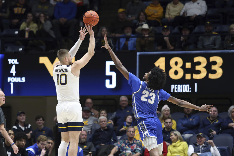 West Virginia guard Erik Stevenson (10) is defended by Buffalo forward Isaiah Adams (23) during the first half of an NCAA college basketball game in Morgantown, W.Va., Sunday, Dec. 18, 2022. (AP Photo/Kathleen Batten)