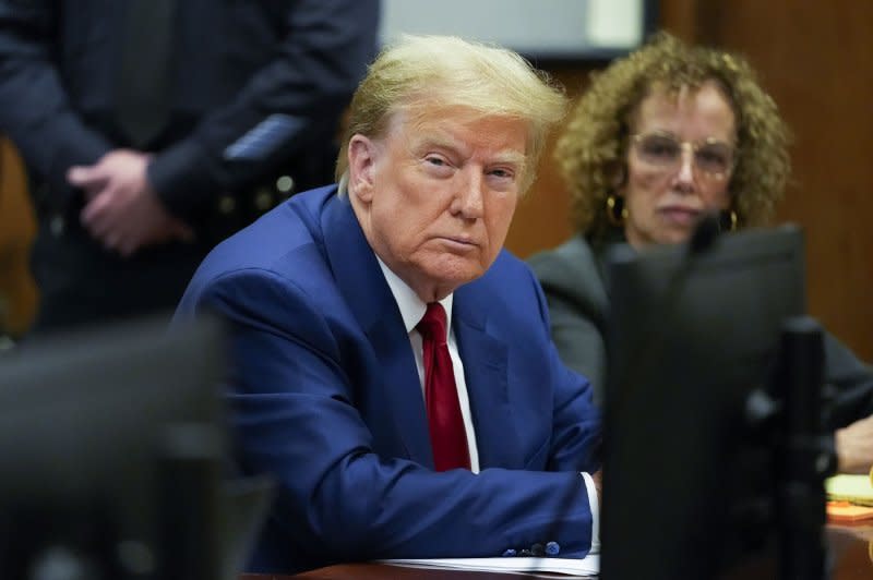 Former President Donald Trump sits in the courtroom at a Monday hearing on charges stemming from hush money paid to an adult film star. Meanwhile, a New York appeals court granted him a delay to pay a bond in the civil fraud case against him -- and cut the required amount. Pool Photo by Mary Altaffer/UPI