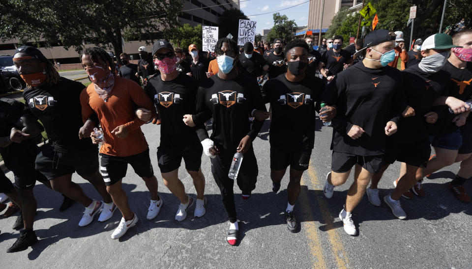 Members of the Austin police department march with members of the University of Texas football team to the State Capitol in Austin, Texas, Thursday, June 4, 2020, during a protest over the death of George Floyd, who died May 25 after being restrained by police in Minneapolis. (AP Photo/Eric Gay)