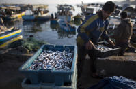 FILE - In this April 3, 2019, file photo, Palestinian fishermen unload their catch after a night fishing trip, in the Gaza Seaport. (AP Photo/Khalil Hamra, File)