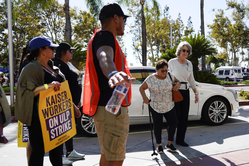 Kaiser Permanent workers wait for a person to cross the picket line Thursday, Oct. 5, 2023, in Baldwin Park, Calif. Some 75,000 Kaiser Permanente hospital employees who say understaffing is hurting patient care walked off the job in five states and the District of Columbia, kicking off a major health care worker strike.(AP Photo/Ryan Sun)
