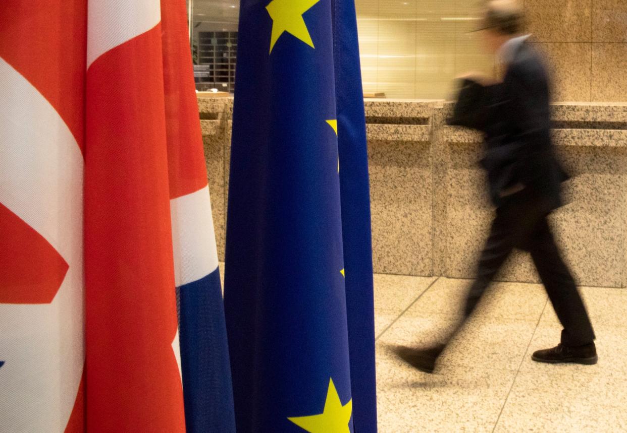 A man walks by the Union Flag and the EU flag inside the European Council building in Brussels: AP