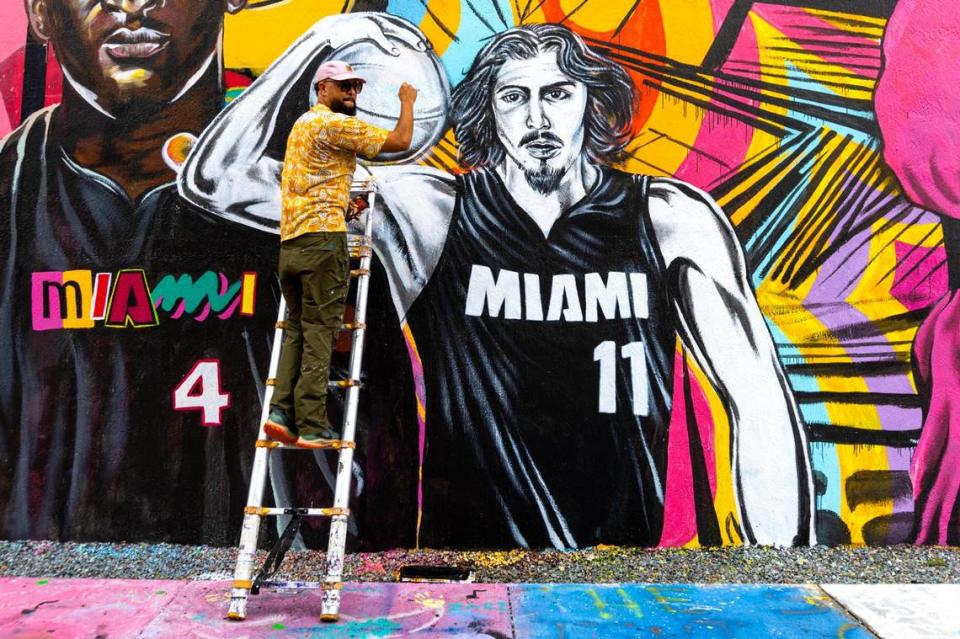 Muralist Kyle Holbrook paints a portrait of rookie Jaime Jaquez Jr. to his Miami Heat inspired mural in the Wynwood neighborhood of Miami, Florida, on Thursday, November 2, 2023. Holbrook opened his non-profit Moving the Lives of Kids Community Mural Project (MLK Mural) in 2002.