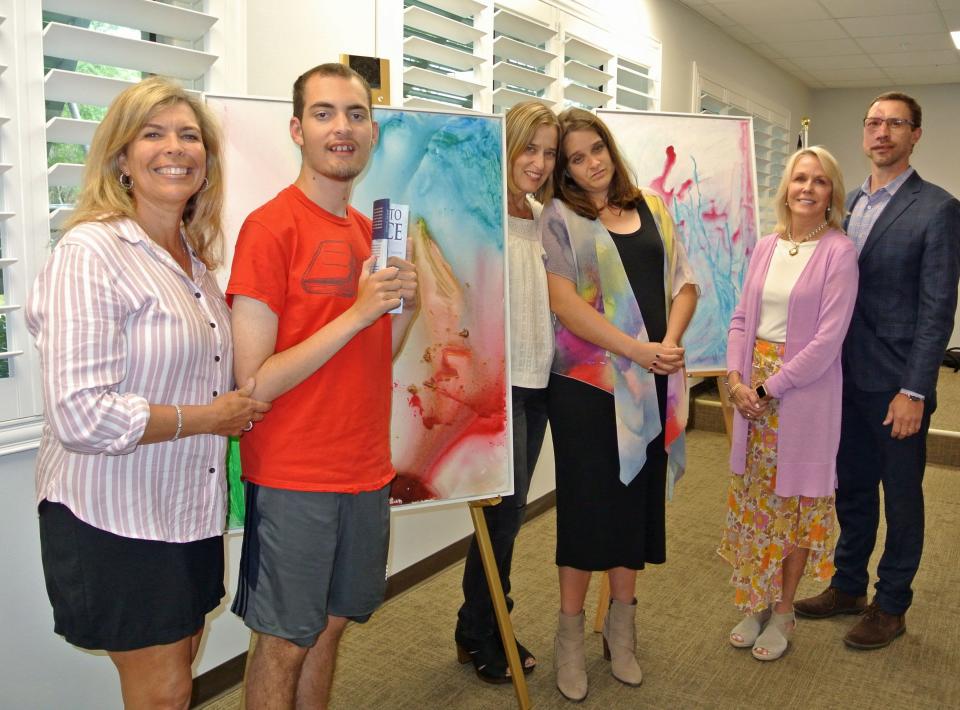 With Danielle Wright (from left) and her non-verbal autistic son Brady, author of "Hostage To Silence," are Amy Groshell and her autistic daughter, Gentry, who illustrated Brady's book; Leslie Weed, founder of the HEAL Foundation; and Marcus Sowcik, director of BridgeHaven Academy for autistic students. Brady's book is available at the Ponte Vedra Branch library. The paintings were done by Gentry to illustrate Brady's book.