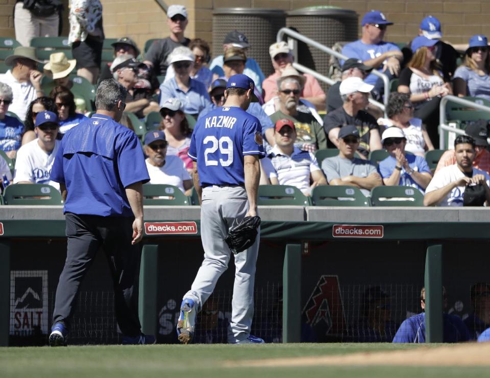 Los Angeles Dodgers' Scott Kazmir leaves with a trainer during the second inning of a spring training baseball game against the Colorado Rockies, Monday, March 6, 2017, in Scottsdale, Ariz. (AP Photo/Darron Cummings)