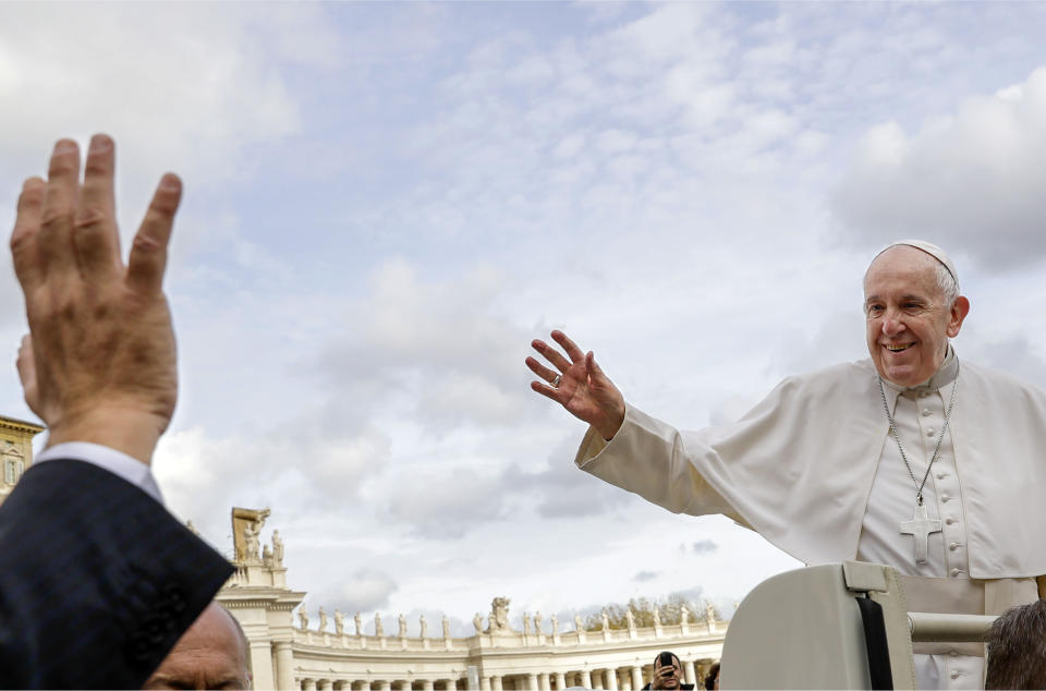 Pope Francis, right, waves as he leaves at the end of his weekly general audience, in St. Peter's Square at the Vatican, Wednesday, Nov. 27, 2019. (AP Photo/Andrew Medichini)