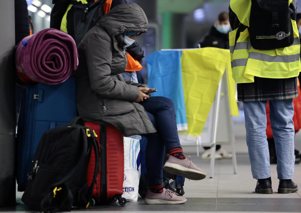 BERLIN, GERMANY - MARCH 01: A women waits beside a Ukrainian flag after refugees from the Ukraine arrive at the main train station on March 1, 2022 in Berlin, Germany. Governments around the world are still struggling to evacuate their citizens caught between Russia's armed invasion and the mounting humanitarian crisis as Ukrainians flee to neighbouring countries. Russia's large-scale invasion of Ukraine started on February 24, 2022, and although the capital was quieter overnight, Russian forces continued to mass outside the city. Ukrainian forces waged battle to hold other major cities. (Photo by Hannibal Hanschke/Getty Images)