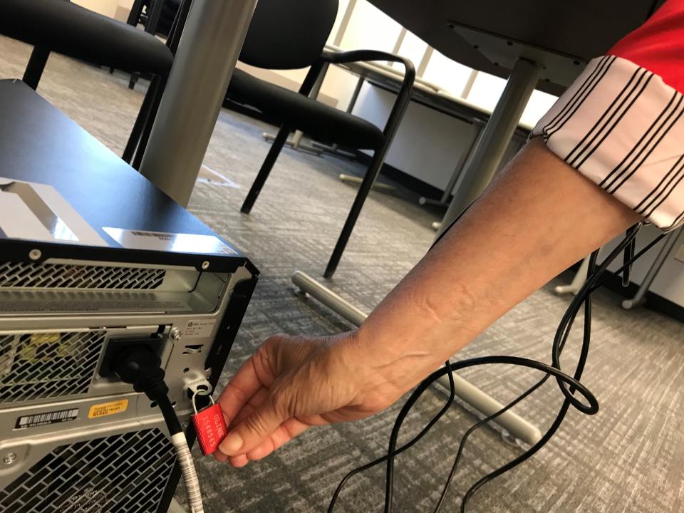 Oakland County Clerk Lisa Brown draws attention for a photo to a lock that guards a computer against tampering at the county's Elections Division offices on Wednesday, July 26, 2023.