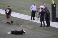 Officials assess the location where the CFL goal post holes were, before an NFL preseason football game between the Oakland Raiders and the Green Bay Packers in Winnipeg, Manitoba, Thursday, Aug. 22, 2019. In the NFL the field goal posts are located at the back of the end zone and the Canadian Football League has the posts at the front of the end zone. (John Woods/The Canadian Press via AP)