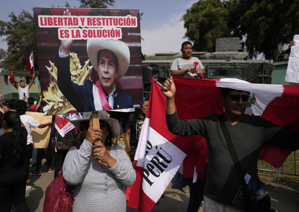 Supporters of former President Pedro Castillo gather outside the police base where he is being held following his arrest and faces charges of rebellion on the outskirts of Lima, Peru, Wednesday, Dec. 14, 2022. Peru's new government declared a 30-day national emergency on Wednesday amid violent protests following Castillo's ouster, suspending the rights of "personal security and freedom" across the Andean nation.(AP Photo/Martin Mejia)