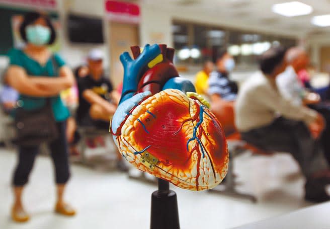 消基會透過「醫材比價網」調查發現，同款式人工心律調節器價差竟可達3.48倍，生物組織心臟瓣膜甚至價差達9萬2500元。圖為心臟模型，背景為民眾在醫院候診。（本報資料照片）