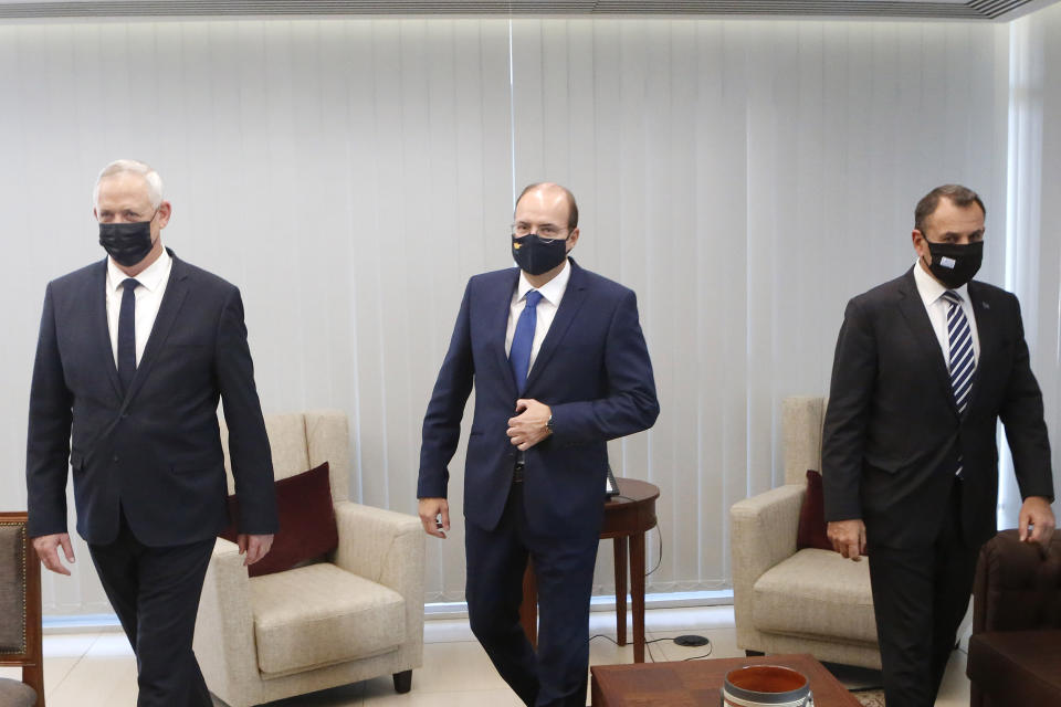 Cyprus' Defense Minister Charalambos Petrides, center, meets with his Israeli counterpart Benny Ganz, left, on his first visit to Cyprus and his Greek counterpart Nikolaos Panagiotopoulos, right, ahead of their meeting aimed at bolstering defense ties in the Cypriot capital Nicosia, Cyprus, on Thursday, Nov. 12, 2020. Greece, Cyprus and Israel have in recent years forged a closer partnership that they say aims to strengthen security and stability in the eastern Mediterranean. (AP Photo/Petros Karadjias)