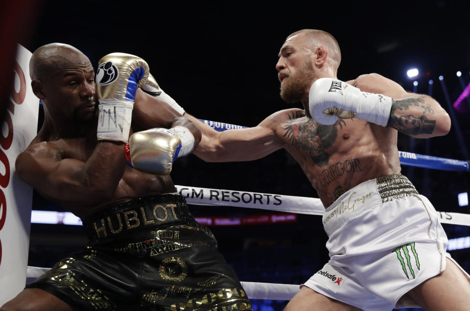 <p>Conor McGregor, right, hits Floyd Mayweather Jr. in a super welterweight boxing match Saturday, Aug. 26, 2017, in Las Vegas. (AP Photo/Isaac Brekken) </p>