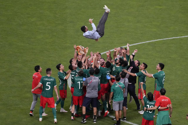 Players of Mexico throw coach Jaime Lozano to celebrate beating 3-1 Japan in the men's bronze medal soccer match at the 2020 Summer Olympics, Friday, Aug. 6, 2021, in Saitama, Japan. (AP Photo/Gregorio Borgia)