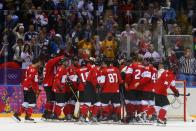 Fans look on as Canada's players celebrate defeating Sweden in their men's ice hockey gold medal game at the Sochi 2014 Winter Olympic Games February 23, 2014. REUTERS/Laszlo Balogh (RUSSIA - Tags: SPORT ICE HOCKEY OLYMPICS)