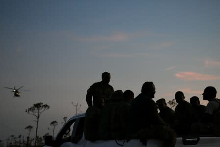 FILE PHOTO - Members of the Bahamian military ride in the back of a truck in the wake of Hurricane Dorian in Marsh Harbour