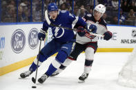 Tampa Bay Lightning defenseman Emil Lilleberg (78) gets hooked by Columbus Blue Jackets defenseman Damon Severson during the second period of an NHL hockey game Tuesday, April 9, 2024, in Tampa, Fla. (AP Photo/Chris O'Meara)