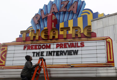 General Manager Brandon Delaney looks up at the marquee sign after the announcement that the Plaza Theatre would be showing the movie "The Interview" beginning Christmas Day in Atlanta, Georgia December 23, 2014. REUTERS/Tami Chappell