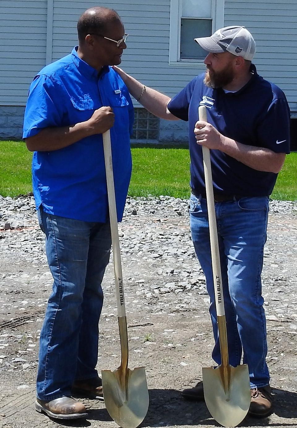 Pastor Stan Braxton and Mayor Mark Mills talk at a groundbreaking for a new food pantry building by Upper Room Assembly and Worship Center. It will feature a covered drive-thru, food storage and space for youth programming.