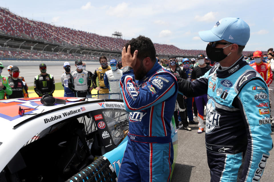 TALLADEGA, ALABAMA - JUNE 22: Bubba Wallace, driver of the #43 Victory Junction Chevrolet, is greeted by Kevin Harvick, driver of the #4 Busch Light Ford, after NASCAR drivers pushed Wallace to the front of the grid as a sign of solidarity with the driver prior to the NASCAR Cup Series GEICO 500 at Talladega Superspeedway on June 22, 2020 in Talladega, Alabama. A noose was found in the garage stall of NASCAR driver Bubba Wallace at Talladega Superspeedway a week after the organization banned the Confederate flag at its facilities. (Photo by Chris Graythen/Getty Images)