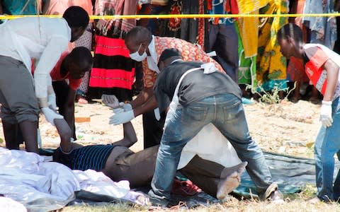 Tanzanian rescue workers remove bodies of victims from the water - Credit: AFP