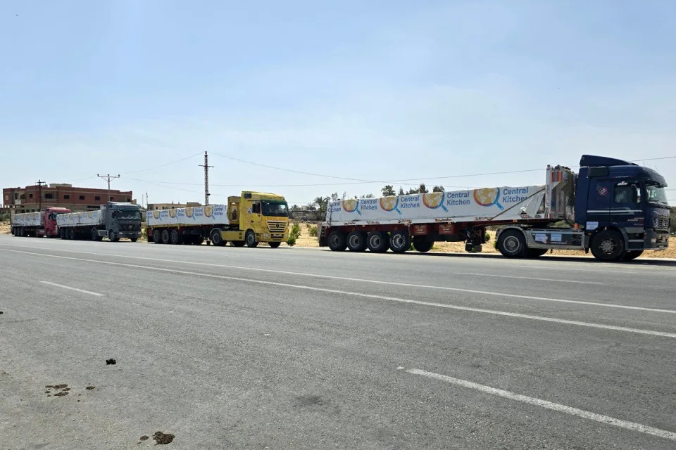 Trucks carrying humanitarian aid bound for the Gaza Strip wait near the Rafah border on Sunday (AFP)