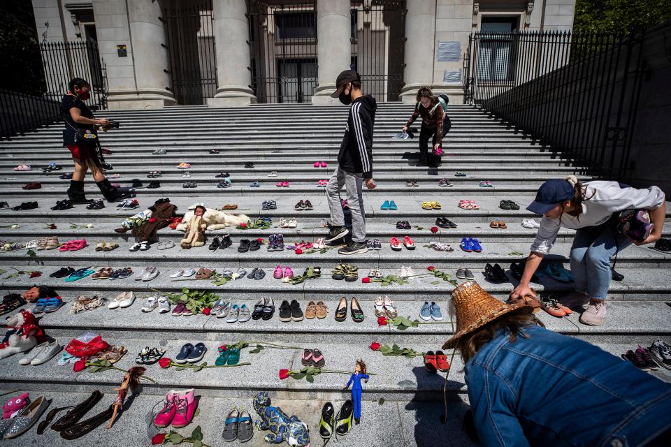 People place 215 pairs of children's shoes on the steps of the Vancouver Art Gallery as a memorial to the 215 children whose remains have been found buried at the site of a former residential school in Kamloops, in Vancouver, British Columbia, Canada on Friday, May 28, 2021.