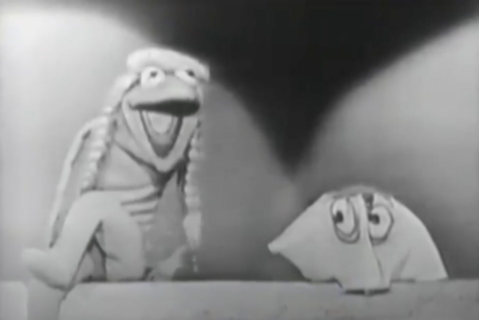 Jim Henson's puppets, Kermit the Frog and Yorick, from a classic black-and-white television appearance, with Kermit wearing a happy expression