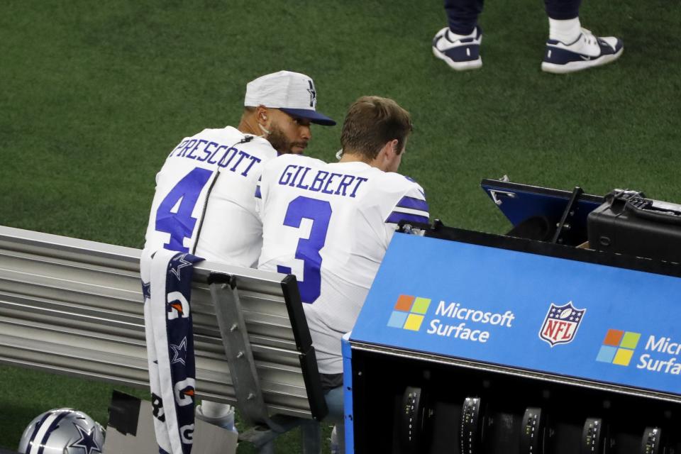 Dallas Cowboys quarterback Dak Prescott (4) and quarterback Garrett Gilbert (3) talk on the sideline in the first half of a preseason NFL football game against the Houston Texans in Arlington, Texas, Saturday, Aug. 21, 2021. (AP Photo/Roger Steinman)