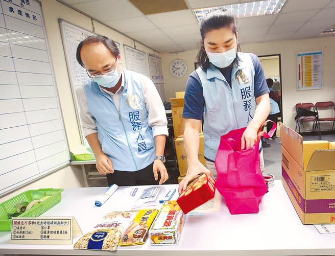 居家隔離人數隨著疫情急速暴增，台北市12個區級關懷中心20日起正式上線，信義區關懷中心工作人員正在準備防疫關懷包給居隔民眾。（范揚光攝）