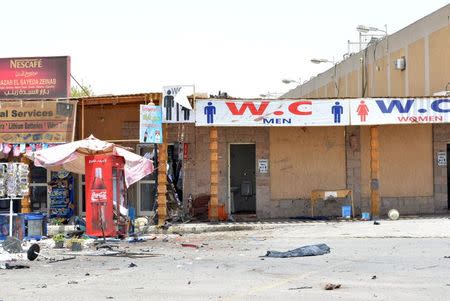 The remains of the body of a suicide bomber is covered on the ground in front of tourist shops, at the scene of a foiled suicide attack in Luxor, Egypt, June 10, 2015. REUTERS/Stringer