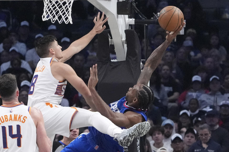 Los Angeles Clippers forward Kawhi Leonard, right, shoots as Phoenix Suns guard Grayson Allen, center, defends and forward Drew Eubanks watches during the first half of an NBA basketball game Monday, Jan. 8, 2024, in Los Angeles. (AP Photo/Mark J. Terrill)