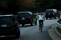 <p>OCT. 28, 2017 – A woman on a bike gestures with her middle finger as a motorcade with President Donald Trump departs Trump National Golf Course October 28, 2017 in Sterling, Virginia. She was fired from her job the following week. (Photo: Brendan Smialowski/AFP/Getty Images) </p>