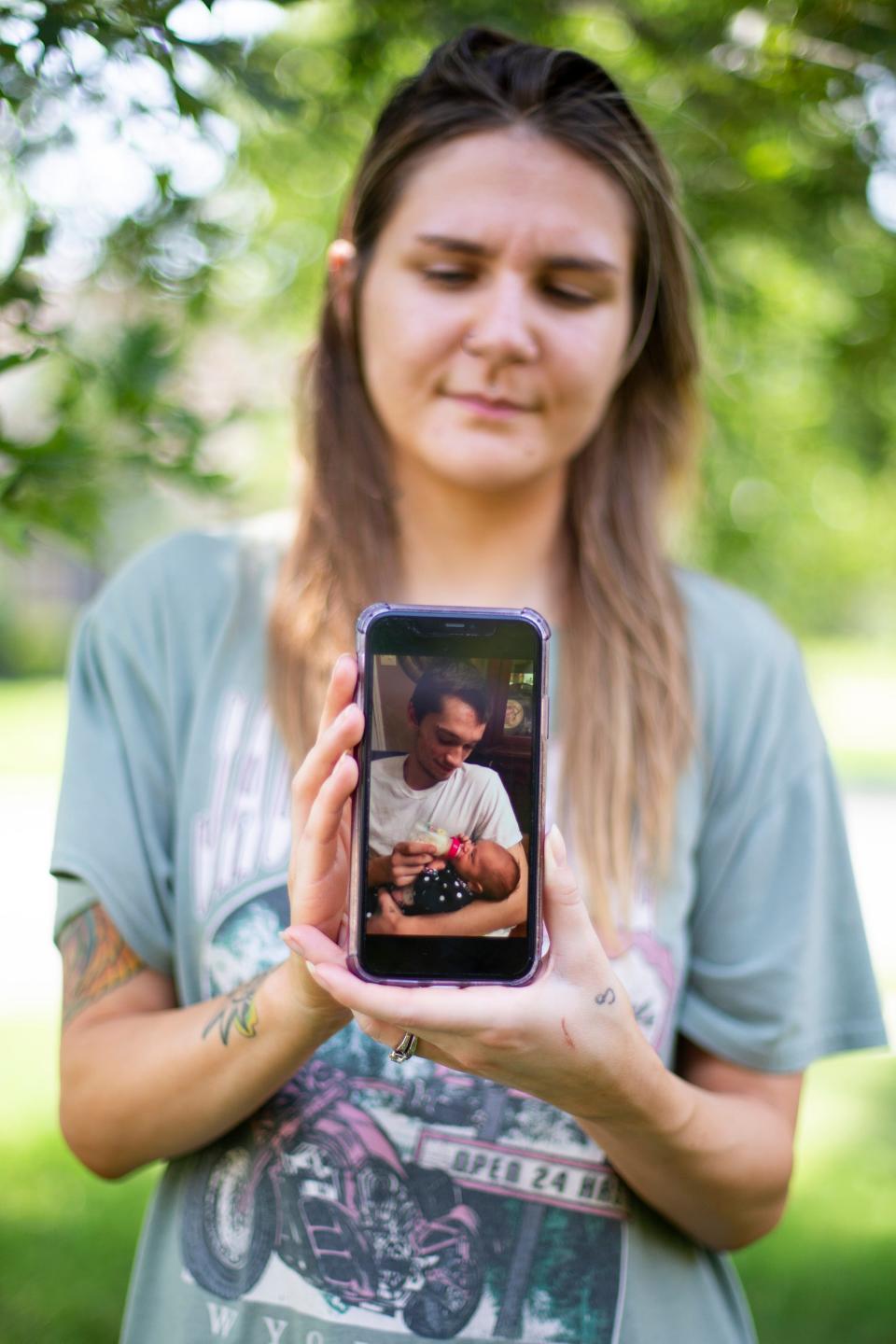 Danielle Harthcock holds up a photo of her fiancèe Steven Gomez holding their daughter Hope Gomez, who is now 5, when she was around four months old outside her home in Olive Branch, Miss., on Thursday, June 29, 2023. Gomez died while in custody of the Shelby County Sheriff’s Office.