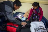 Ovidio Lopez Tum, 53, an asylum seeker from Guatemala, and his daughter Ingrid Maribel, 12, pack up their belongings before taking a bus for Alabama