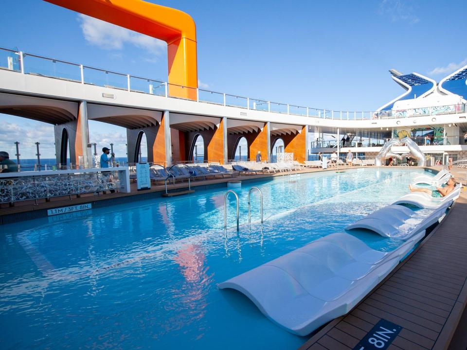 the lounge chairs in a relatively empty pool.