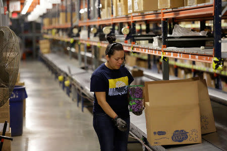 Toys 'R' Us vendor Learning Resources worker places toys in a box along a conveyor belt at the warehouse in Vernon Hills, Illinois, U.S., March 16, 2018. REUTERS/Joshua Lott