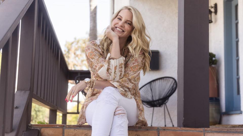 Blonde woman in white jeans sitting on step