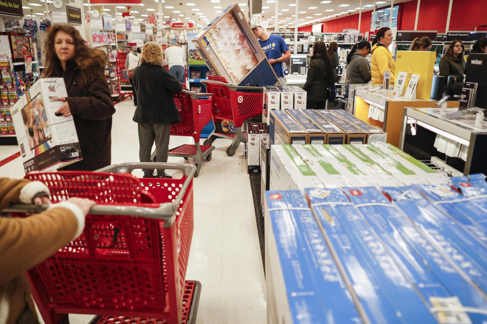 FILE- In this Nov. 23, 2018, file photo shoppers wait in line for iPhone purchases during a Black Friday sale at a Target store in Newport, Ky. Super Bowl season is an excellent time to purchase a new TV, as long as you have room in your home and budget. (AP Photo/John Minchillo, File)