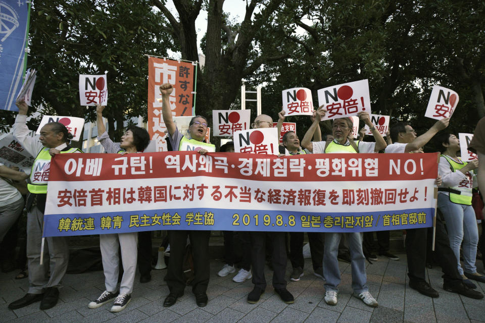 Protesters with "No Abe!" signs chat slogans during a rally outside Japanese Prime Minister Shinzo Abe's residence in Tokyo Thursday, Aug. 8, 2019. More than 100 people staged a rally to urge the government to reverse the recent downgrading of South Korea's trade status and to apologize for wartime atrocities in an effort fix rapidly souring relations. (AP Photo/Eugene Hoshiko)