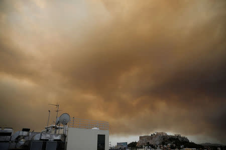 Smoke from a wildfire burning outside Athens is seen over the Parthenon temple atop the Acropolis hill in Athens, Greece, July 23, 2018. REUTERS/Alkis Konstantinidis