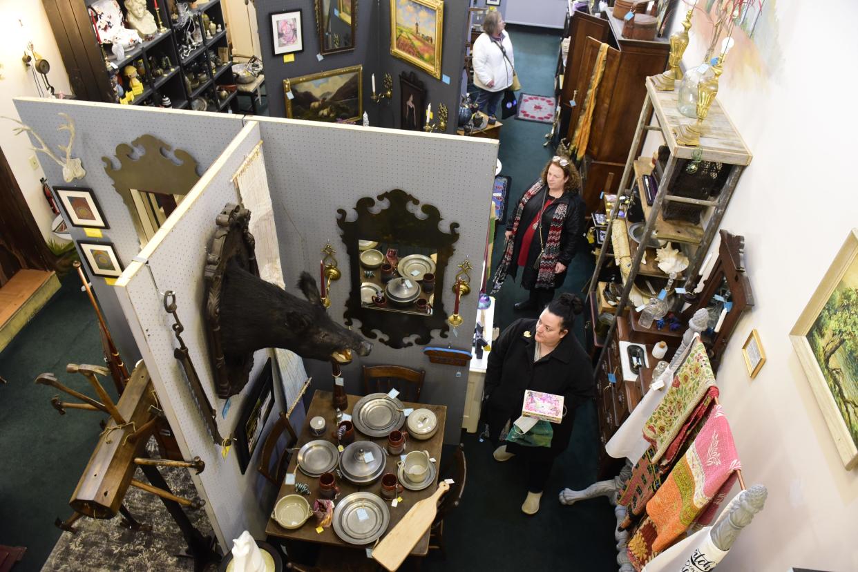 Shoppers look through the art and antiques inside Lucah Designs downtown Mansfield during Small Business Saturday.