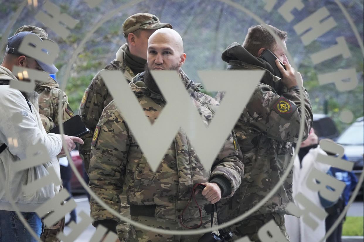 Soldiers wearing military camouflage are visible through a window emblazoned with PMC Wagner Centre.