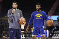 Golden State Warriors assistant coach and director of player development Jama Mahlalela, left, stands next to Golden State Warriors forward Andrew Wiggins during practice before an NBA basketball game against the Detroit Pistons in San Francisco, Tuesday, Jan. 18, 2022. Coach Steve Kerr and his assistants met during the summer along with Stephen Curry and Draymond Green to review how they might practice more efficiently and with greater focus, and the resulting “Golden Hour” has meant so much to Golden State’s success so far.(AP Photo/Jed Jacobsohn)