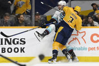 Nashville Predators defenseman Jeremy Lauzon (3) checks Seattle Kraken defenseman Justin Schultz (4) into the boards as they go for the puck during the third period of an NHL hockey game Saturday, March 25, 2023, in Nashville, Tenn. The Kraken won 7-2. (AP Photo/Mark Zaleski)