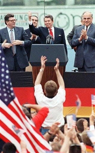 FILE - This June 12, 1987 file photo shows President Reagan giving a thumbs up sign after his speech in front of the Brandenburg Gate in West Berlin, where he had said "Mr. Gorbachev, tear down this wall! " Applauding Reagan are West German Chancellor Helmut Kohl, right, and West German Parliament President Philipp Jenninger, left. As the Feb. 6 centennial of Reagan's birth approaches, and a generation after he exited the White House, the nation's 40th president is enjoying a level of popularity that mostly eluded him while in office.