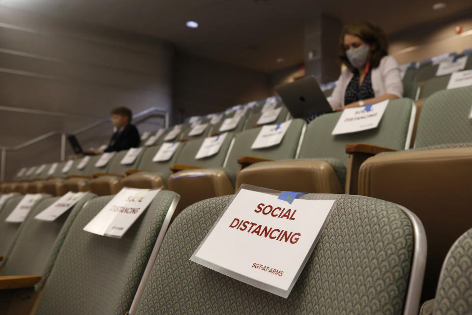 Signs remind members of the media "press pool" to practice social distancing during a hearing of the state Senate budget special subcommittee on COVID-19, at the Capitol in Sacramento, Calif., Thursday, April 16, 2020. Lawmakers are looking into how Gov. Gavin Newsom has been spending money to address the new coronavirus crisis. (AP Photo/Rich Pedroncelli, Pool)